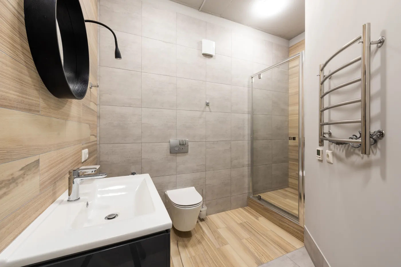 Baño con revestimiento claro y mampara