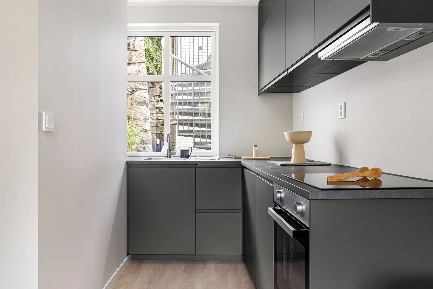 Cocina con muebles grises y mesada oscura