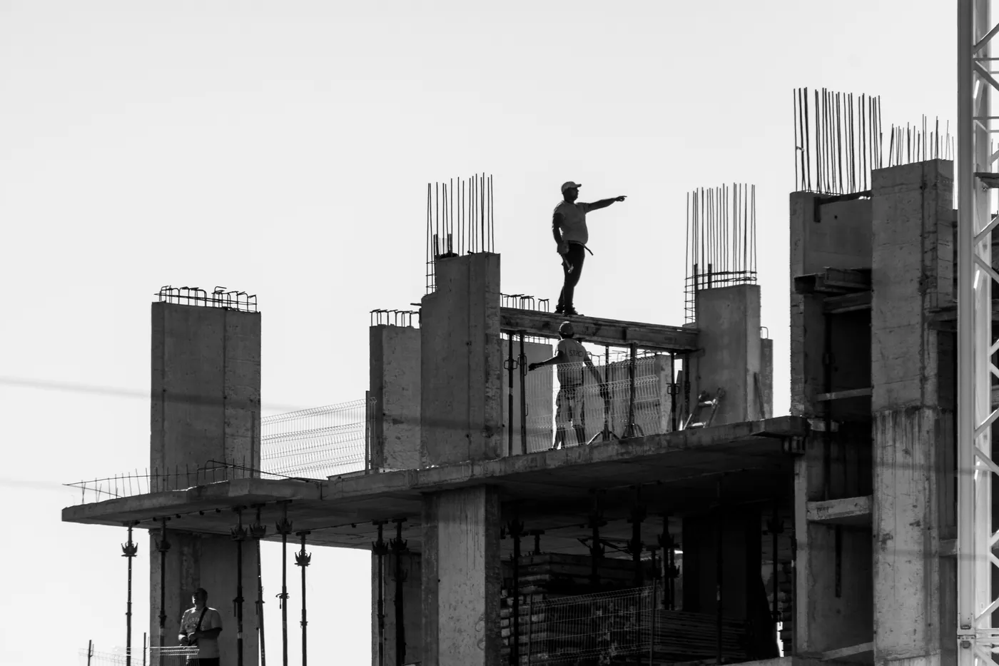 Columnas de hormigón con hierros en espera, en blanco y negro